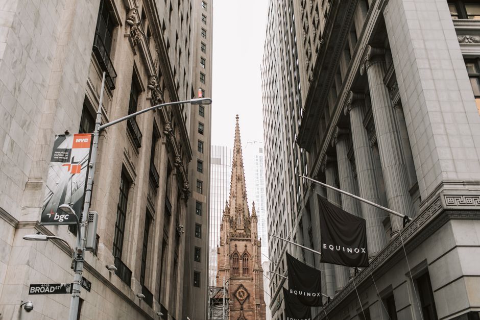 Trinity Church framed by tall office buildings on Broad Street in lower Manhattan, the heart of the Wall Street financial district