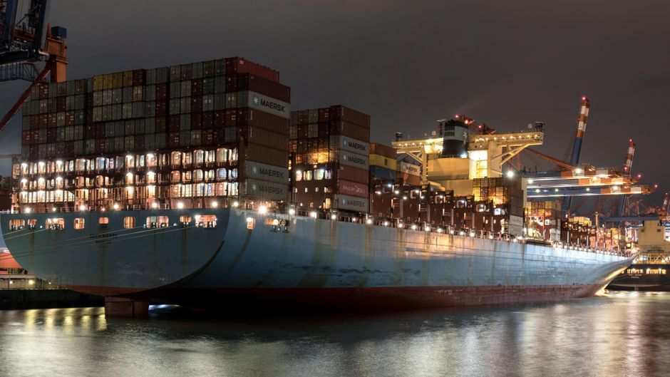 A container ship operates at a commercial port as geopolitical supply risks rise.