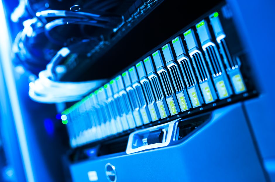 Blue-lit computer hardware represents the infrastructure spending behind the AI and cloud demand debate.