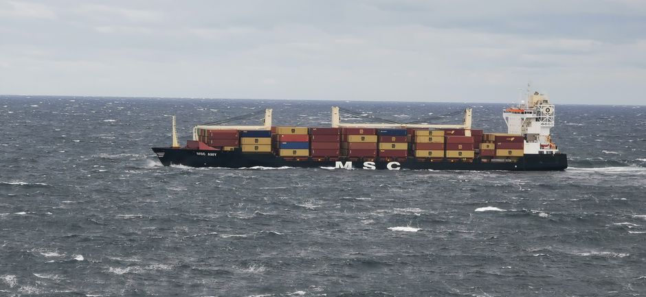 A large cargo vessel transporting containers on the open sea, illustrating commercial shipping through contested maritime chokepoints.