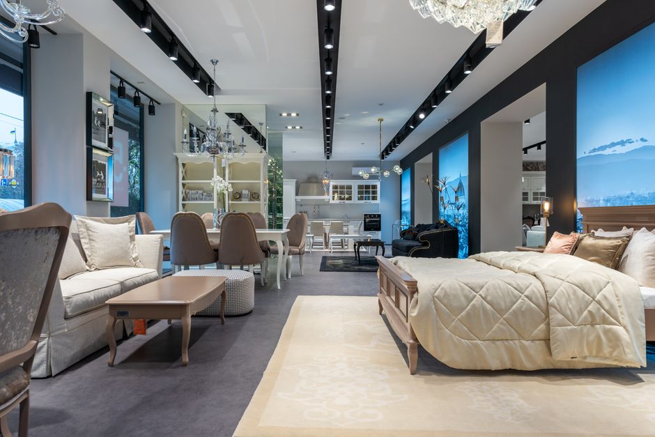 A modern furniture showroom with beds, sofas and dining displays.