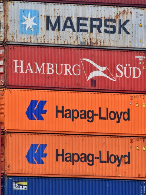 Stacked shipping containers from major global logistics brands at a port terminal.