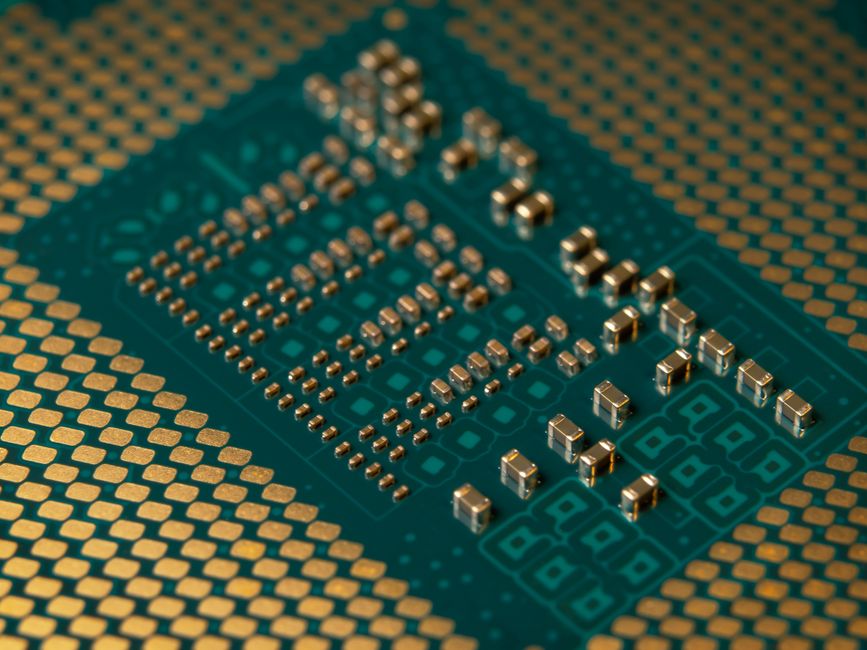 Close-up of a microprocessor circuit board with intricate circuitry, representing semiconductor and AI chip infrastructure.